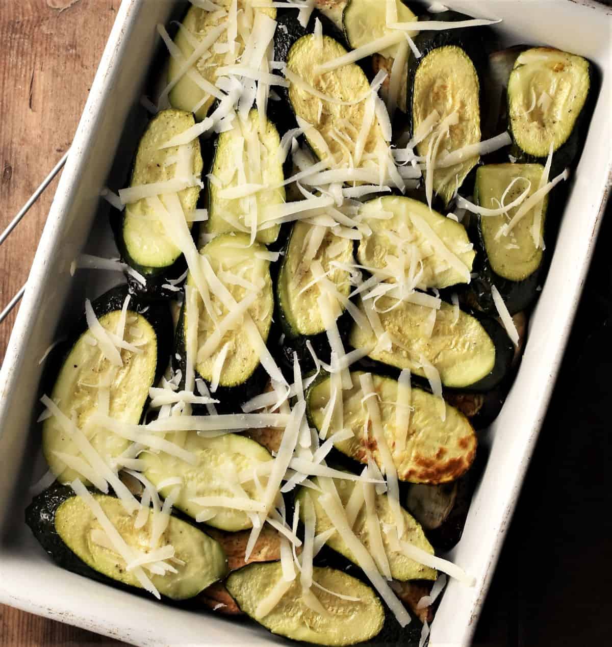 Layering moussaka with eggplant and zucchini slices.