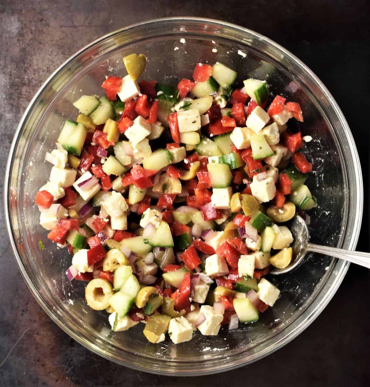 Stuffed tomatoes filling mixture in bowl with spoon.