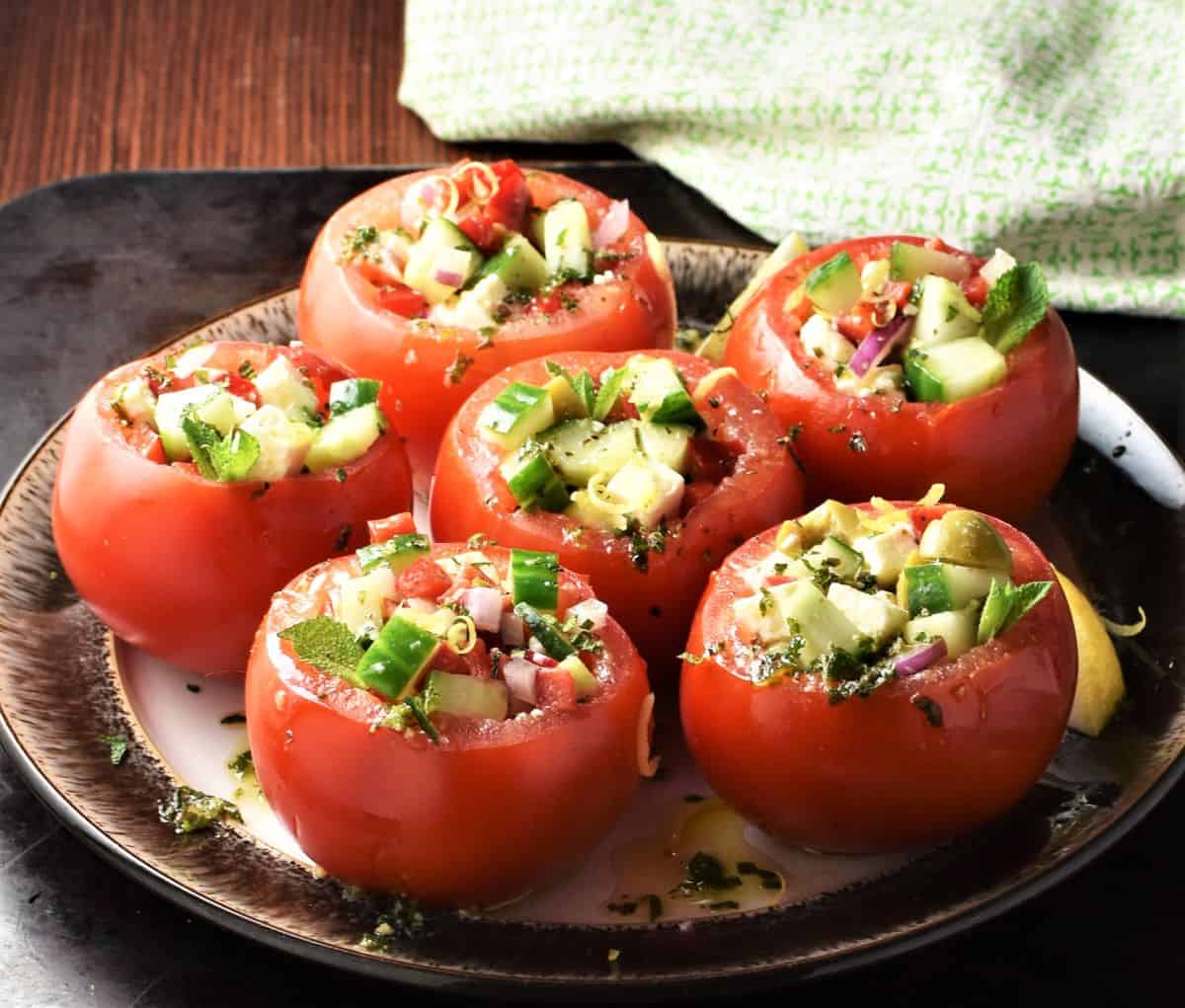 Side view of vegetarian stuffed tomatoes on top of plate.