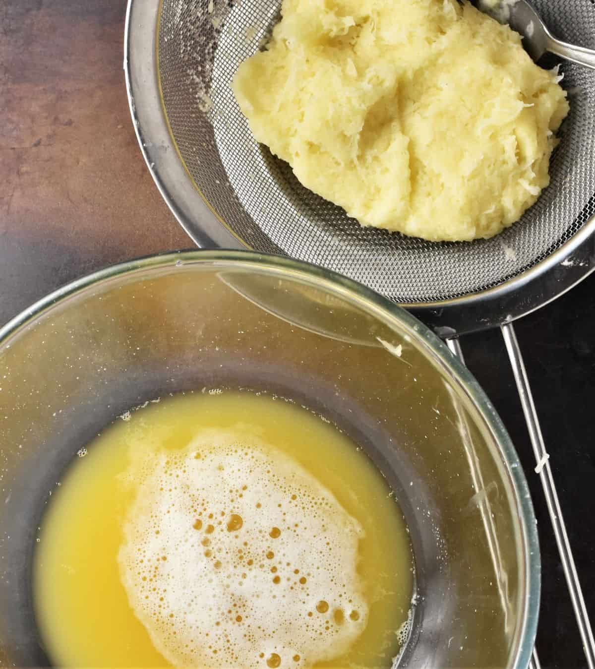 Shredded potato in sieve and potato water in bowl.