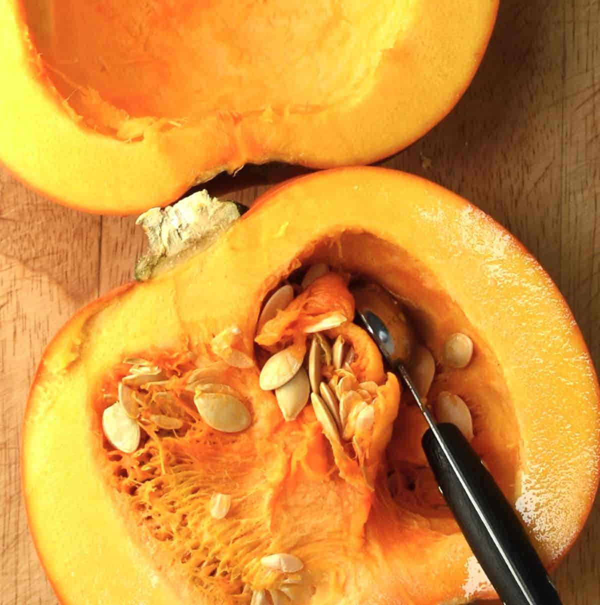 Top down view of removing pumpkin innards using melon baller.