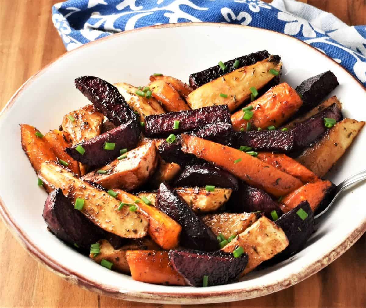 Side view of roasted balsamic vegetables in white bowl.