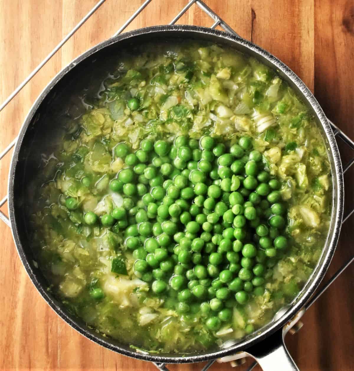 Making brussels sprouts soup with peas in pot.