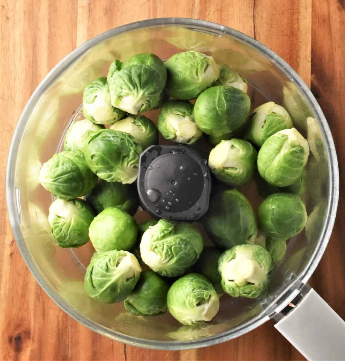 Whole brussels sprouts in blender bowl.