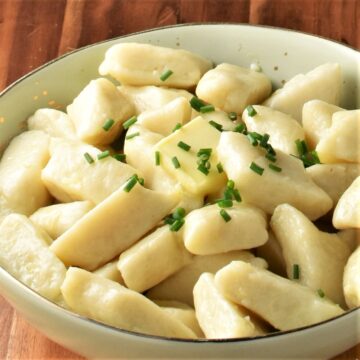 Close-up view of Polish potato dumplings in green bowl.