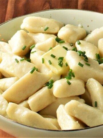 Close-up view of Polish potato dumplings in green bowl.