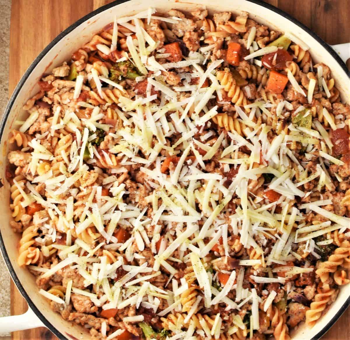 Chicken casserole with grated cheese on top in large round dish.