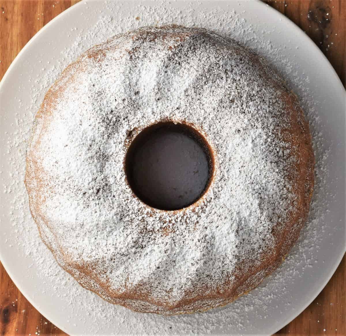 Round babka on white plate dusted with sugar. 