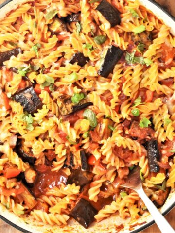 Top down view of eggplant pasta bake in large round dish with spoon.