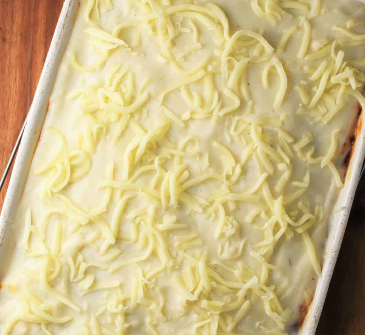 Turkey lasagna topped with creamy white sauce and cheese.