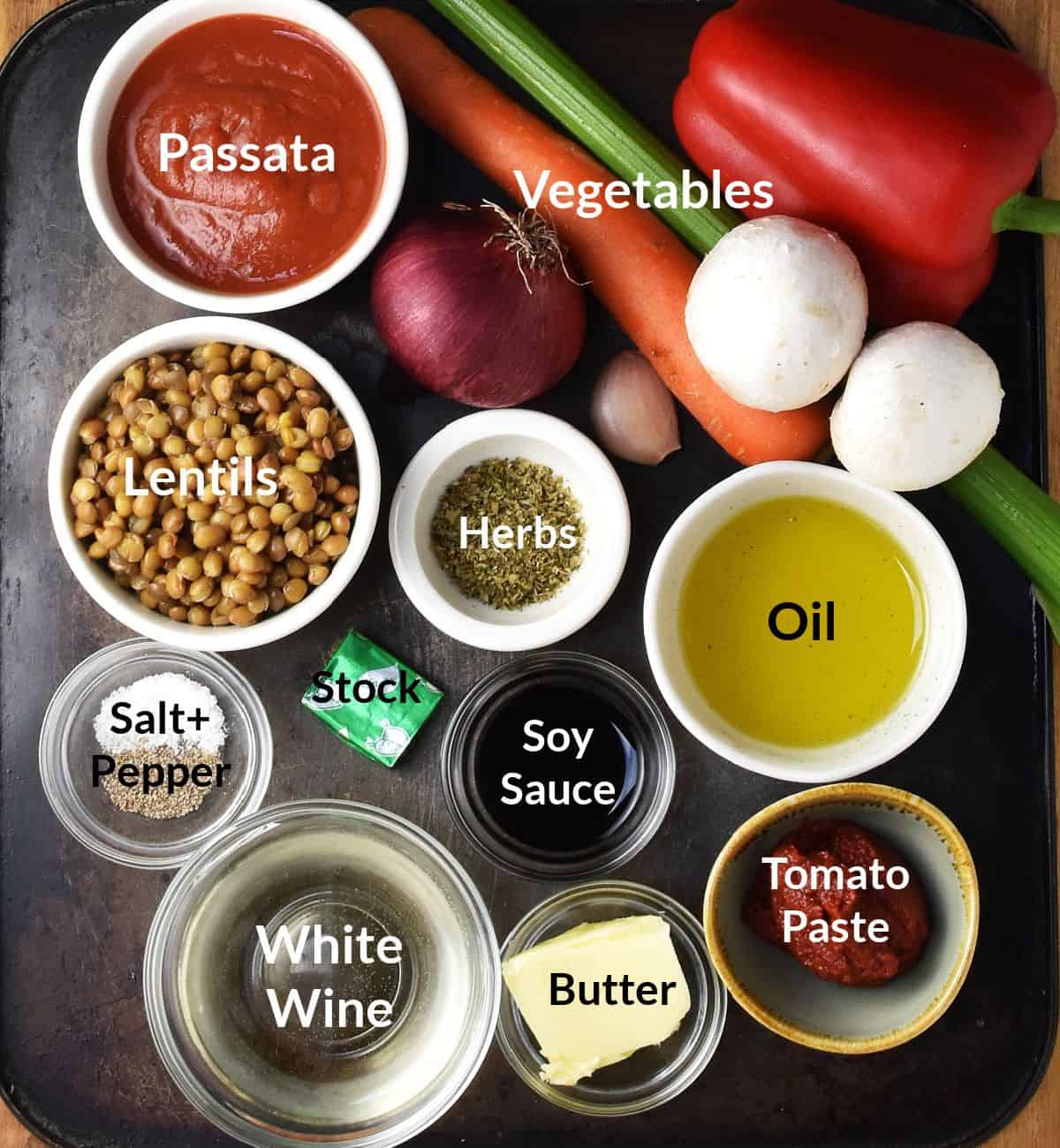 Top down view of lentil ragu sauce ingredients in small, labelled dishes.