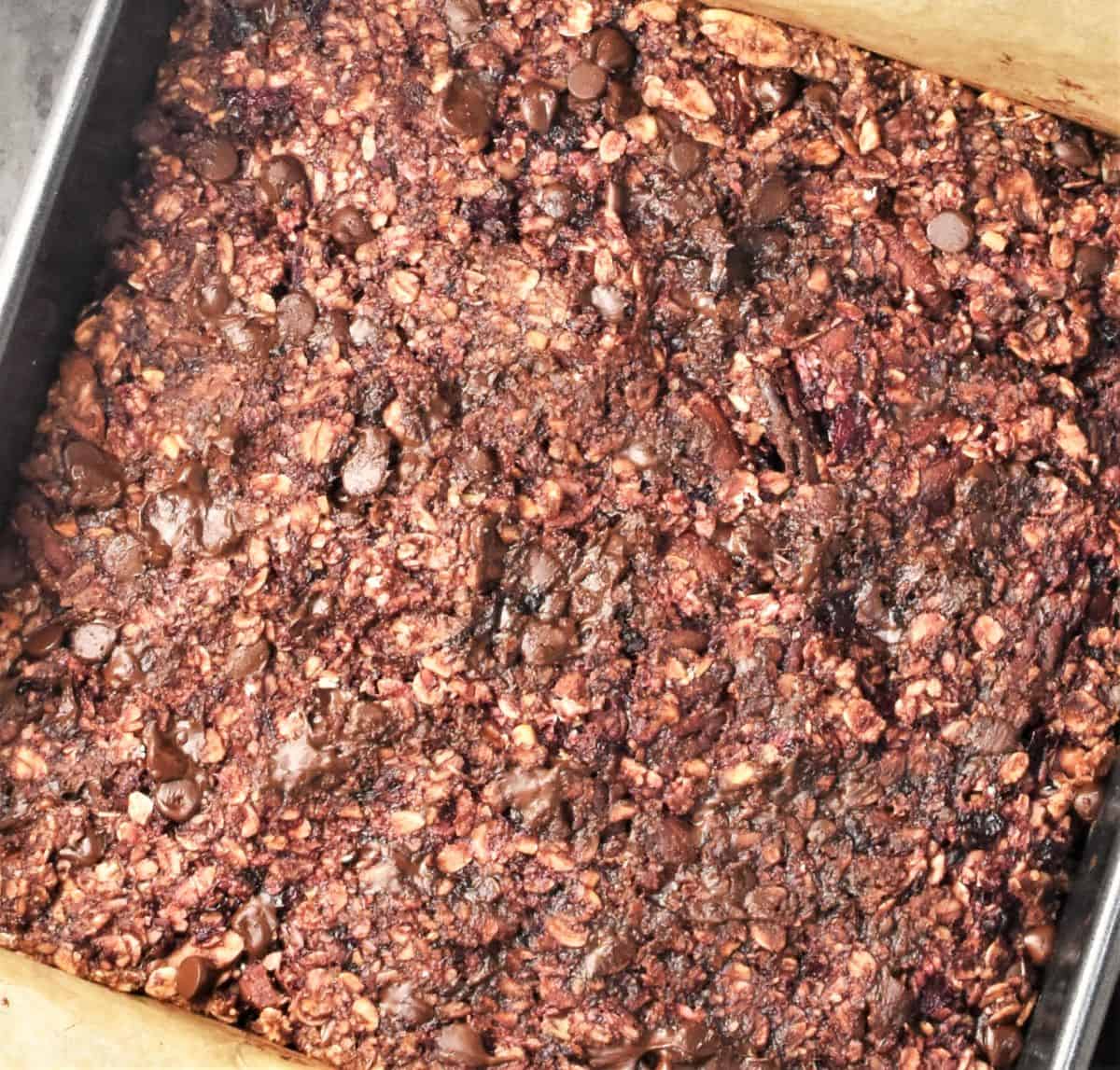 Top down view of blackberry oat bar bake in square pan.