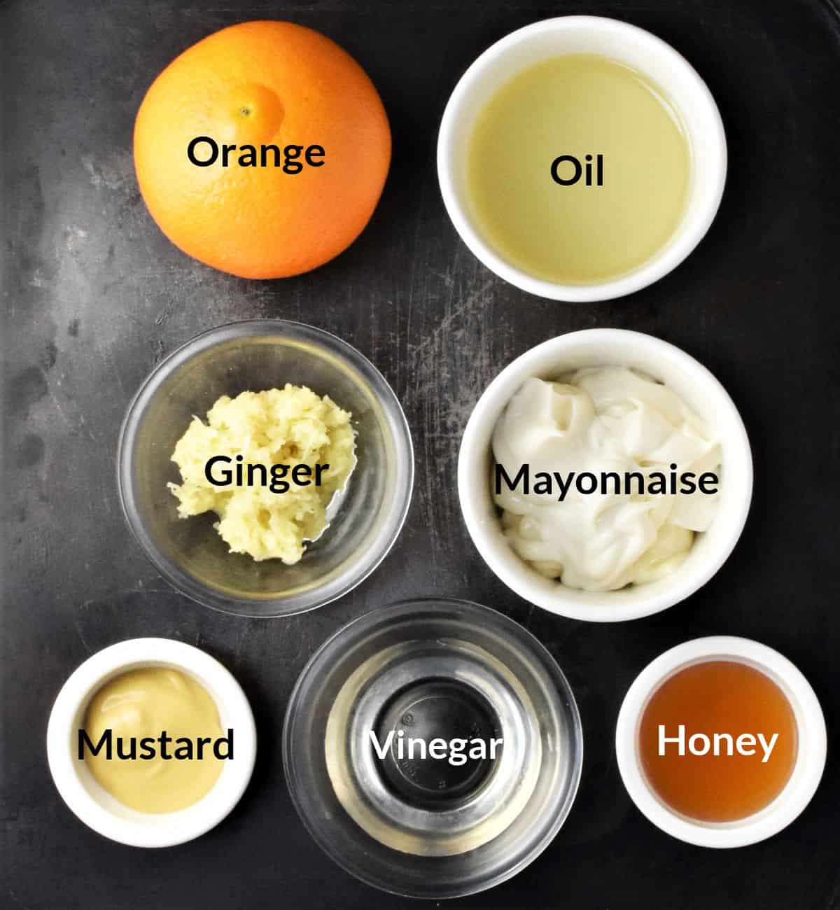 Ingredients for making orange salad dressing in individual dishes.