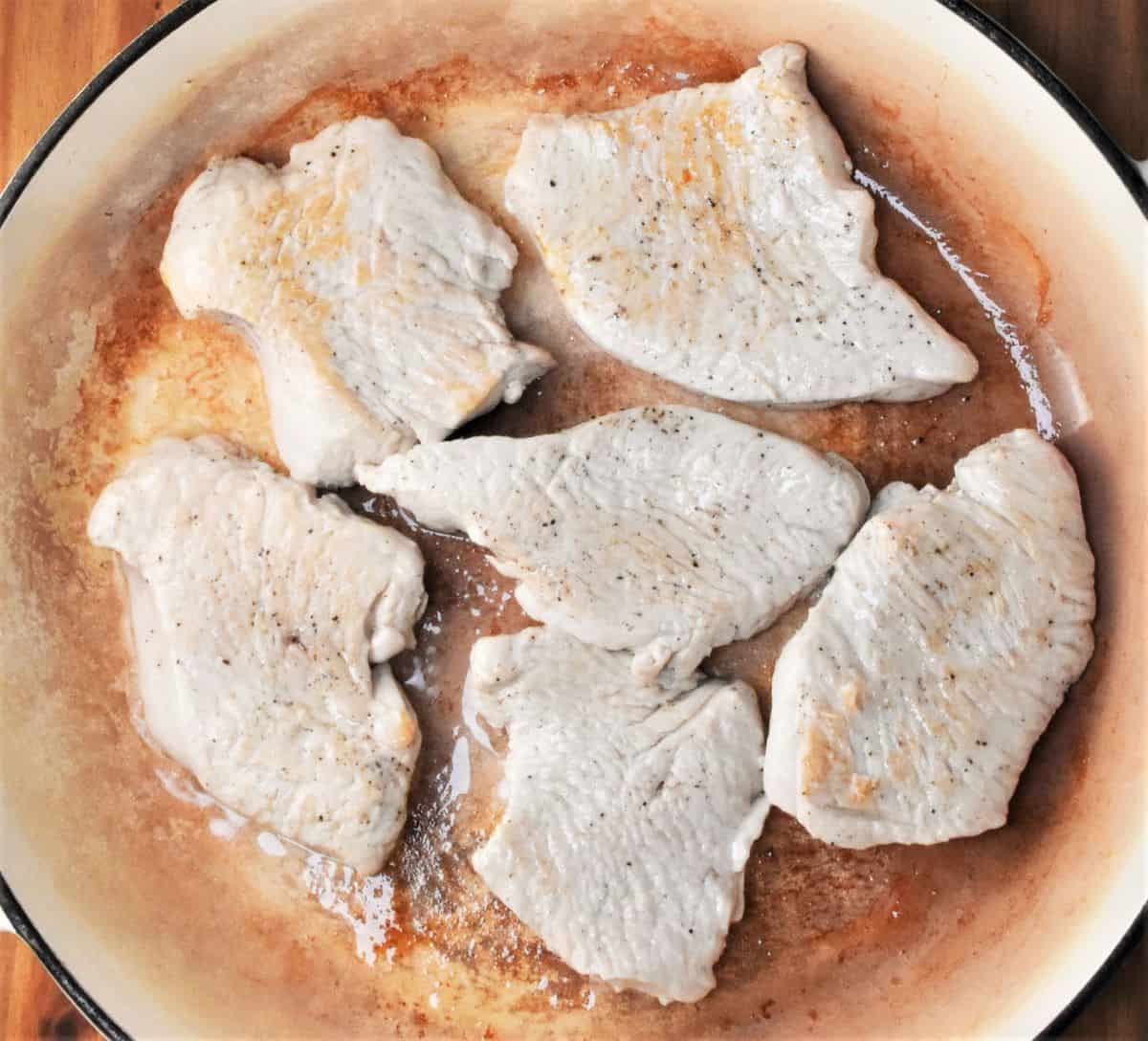Searing turkey breast steaks in large shallow pan.