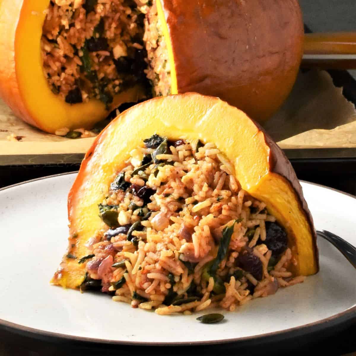 Side view of stuffed pumpkin slice on top of plate and pumpkin in background.