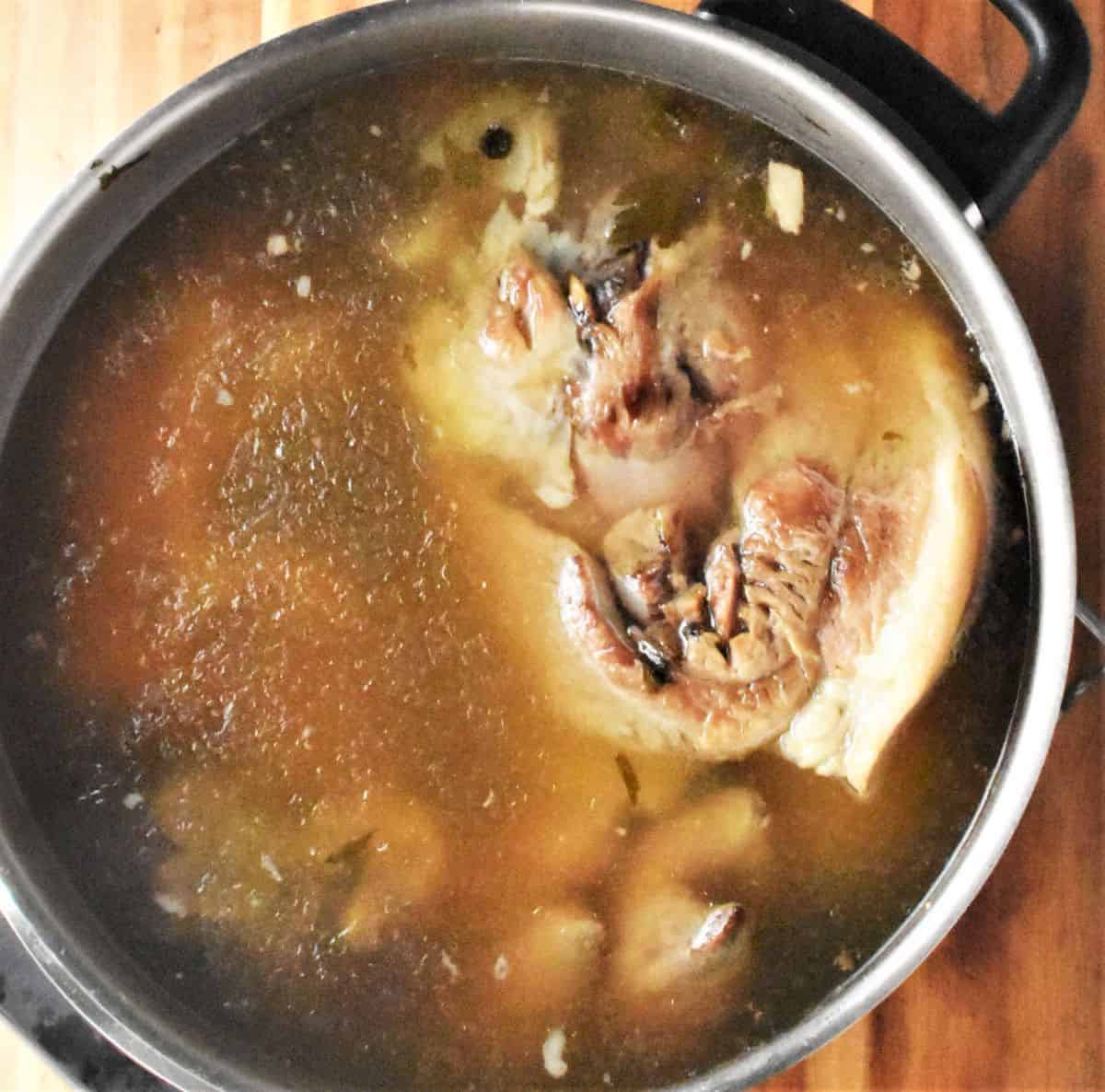 Top down view of cooked pork shank in broth.