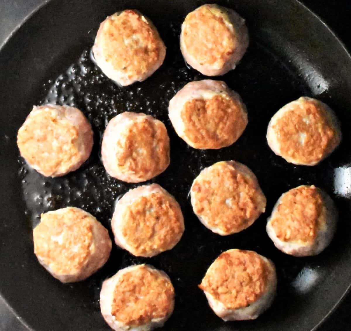 Frying meatballs in pan.