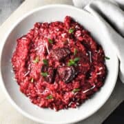 Top down view of beet risotto in grey bowl.