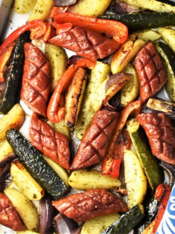 Top down view of baked kielbasa and vegetables.