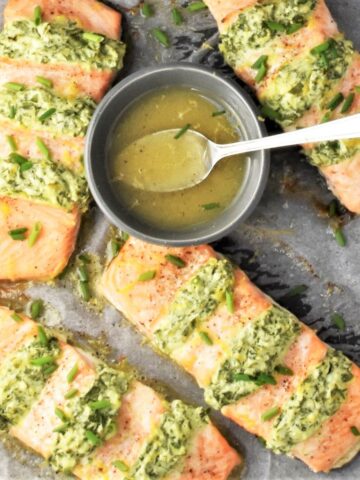 Top down view of hasselback salmon fillets with dressing in bowl.