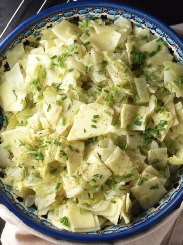 Top down view of cabbage pasta in blue bowl.