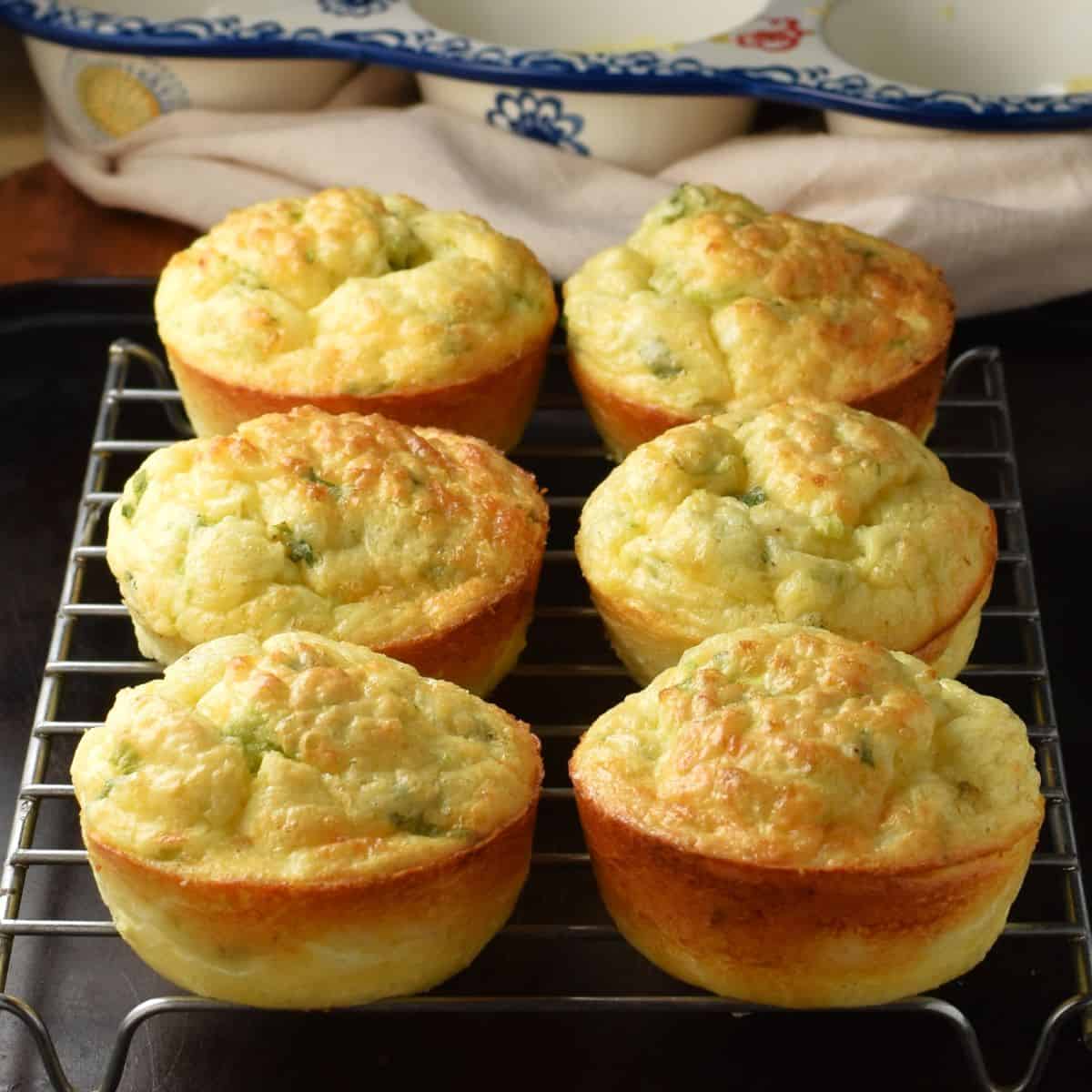 Close-up side view of 6 cottage cheese and egg muffins on top of rack.