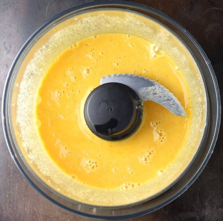 Egg yolk mixture in food processor bowl.