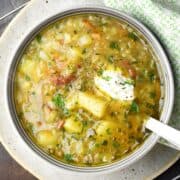 Top down view of Polish potato soup in bowl with spoon.