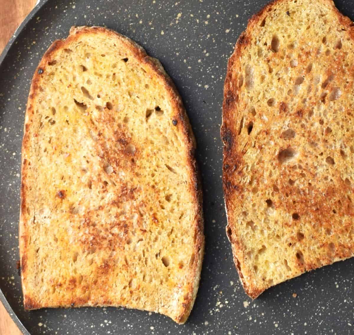 2 pieces of toasted bread in pan.