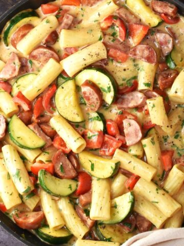 Top down view of kielbasa pasta with vegetables in large pan.