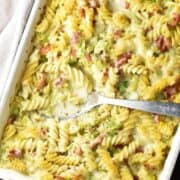 Top down view of brussels sprouts pasta bake with spoon in rectangular dish.