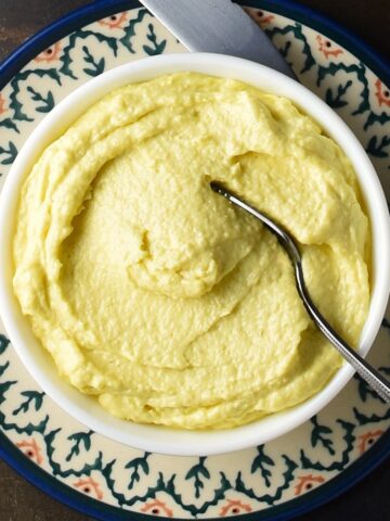 Top down view of creamy horseradish mayonnaise in white bowl with spoon.