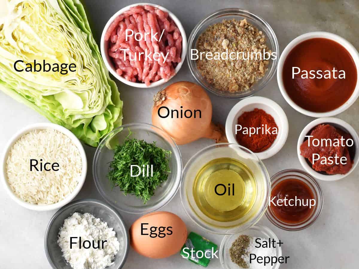Lazy unstuffed cabbage rolls ingredients in individual dishes on marble top.