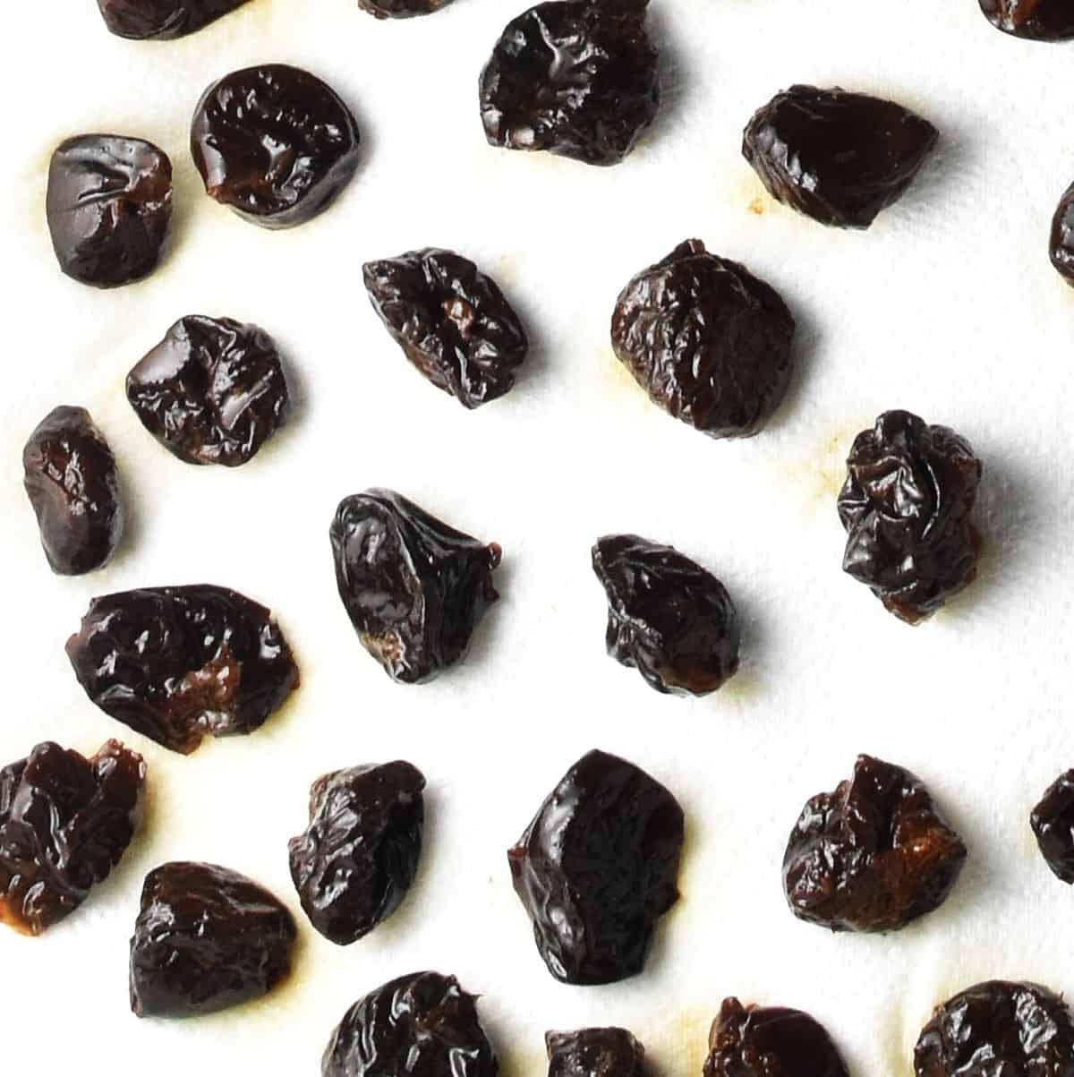 Top down view of prunes drying on paper towel.