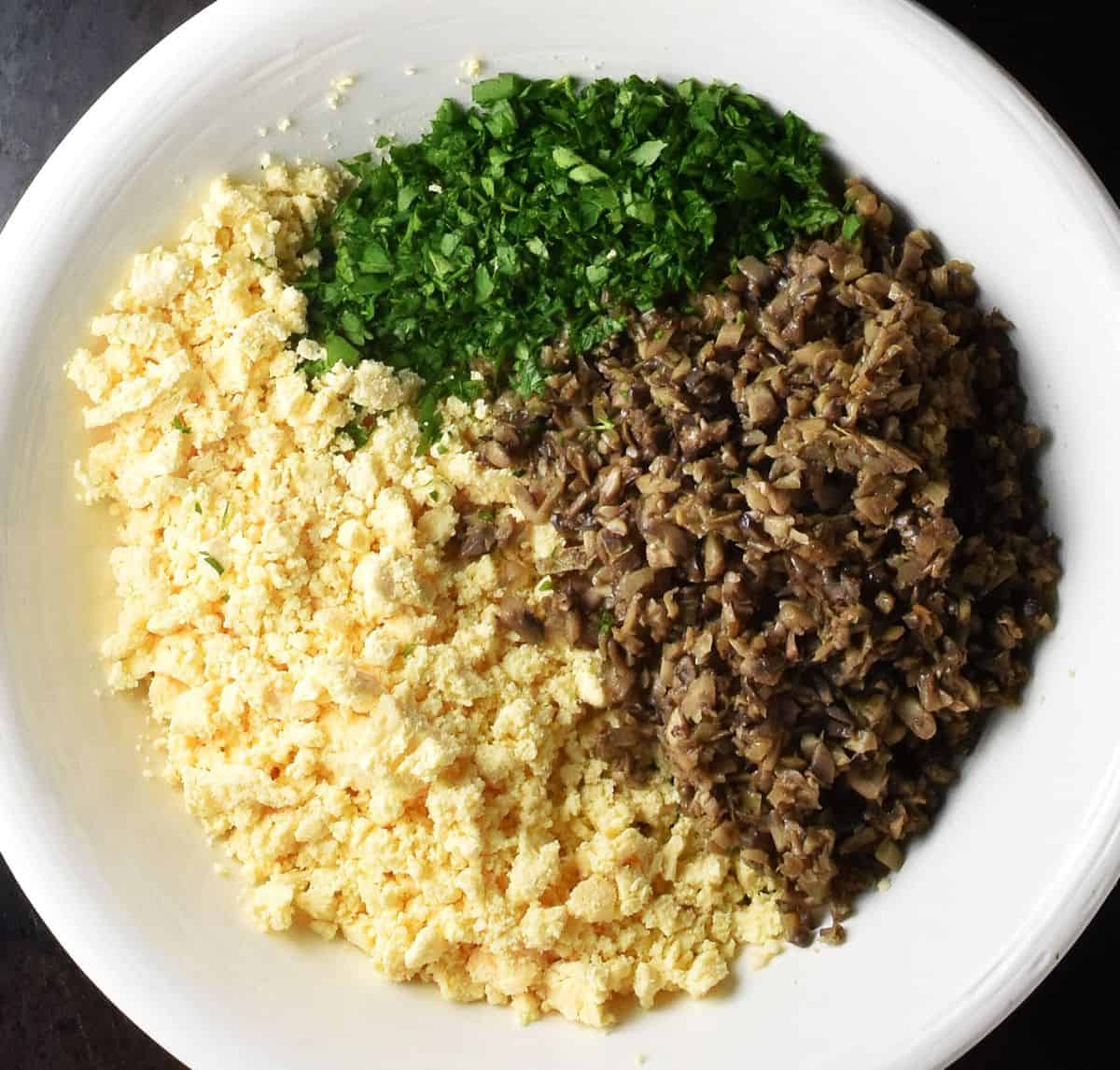 Crumbled egg yolks, sauteed mushroom mixture and chopped parsley in large bowl.