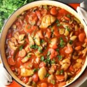 Top down view of chicken goulash in large shallow white pan.