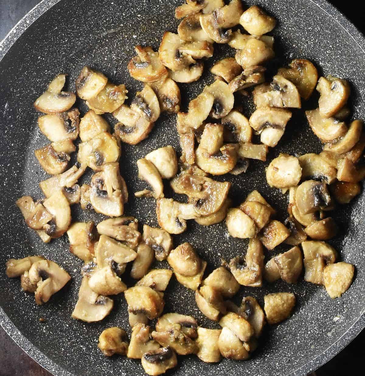 Flour coated mushrooms in large pan.