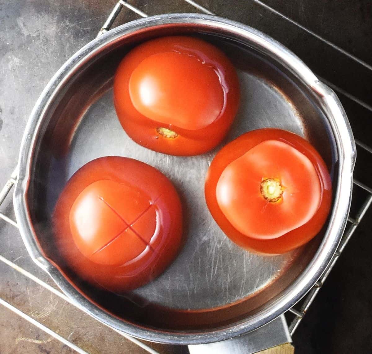 3 large tomatoes in pot of water.