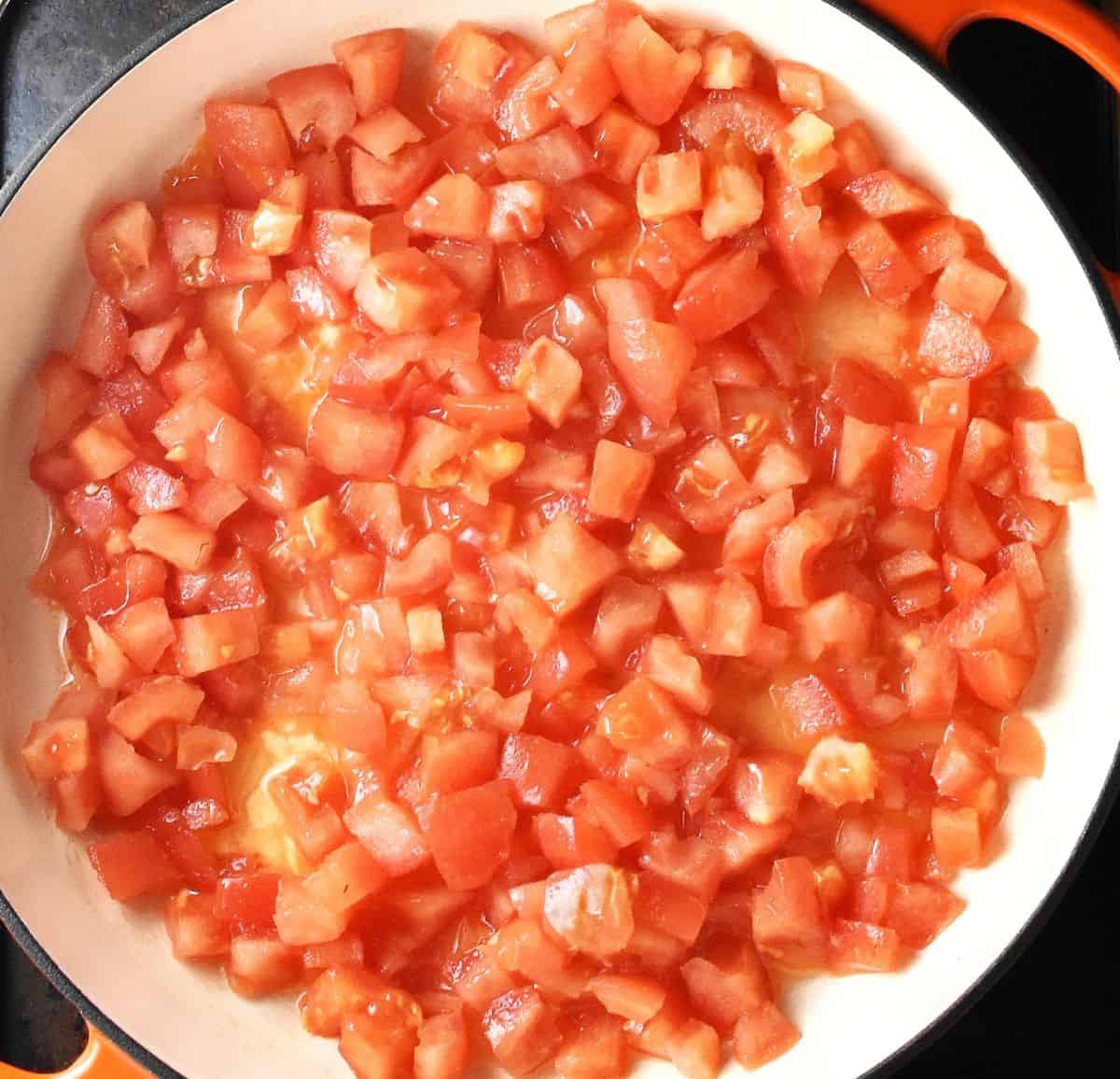 Chopped tomatoes in large white pan.