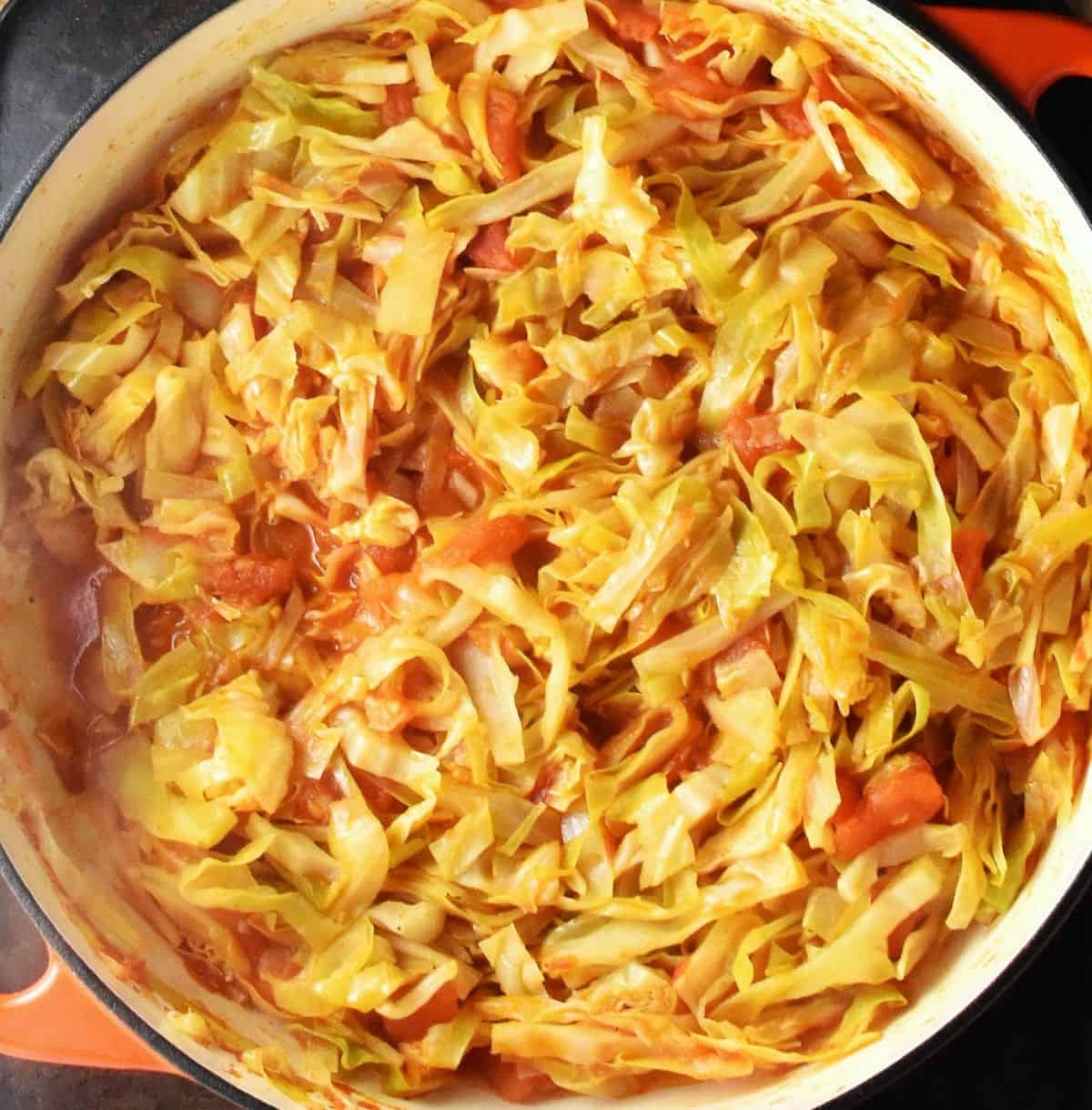 Cooked tomatoes and cabbage in large shallow pan.