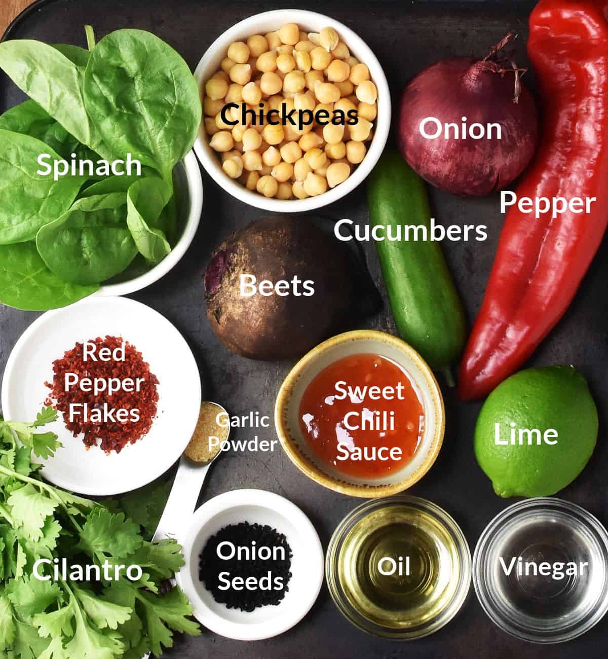 Top down view of ingredients for roasted beet and chickpea salad in individual dishes and labelled.